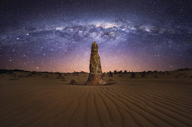 The Milky Way arching over a single pillar in the Pinnacles Desert