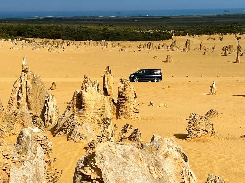 A vehicle on the one-way Pinnacles Desert Drive between the pillars